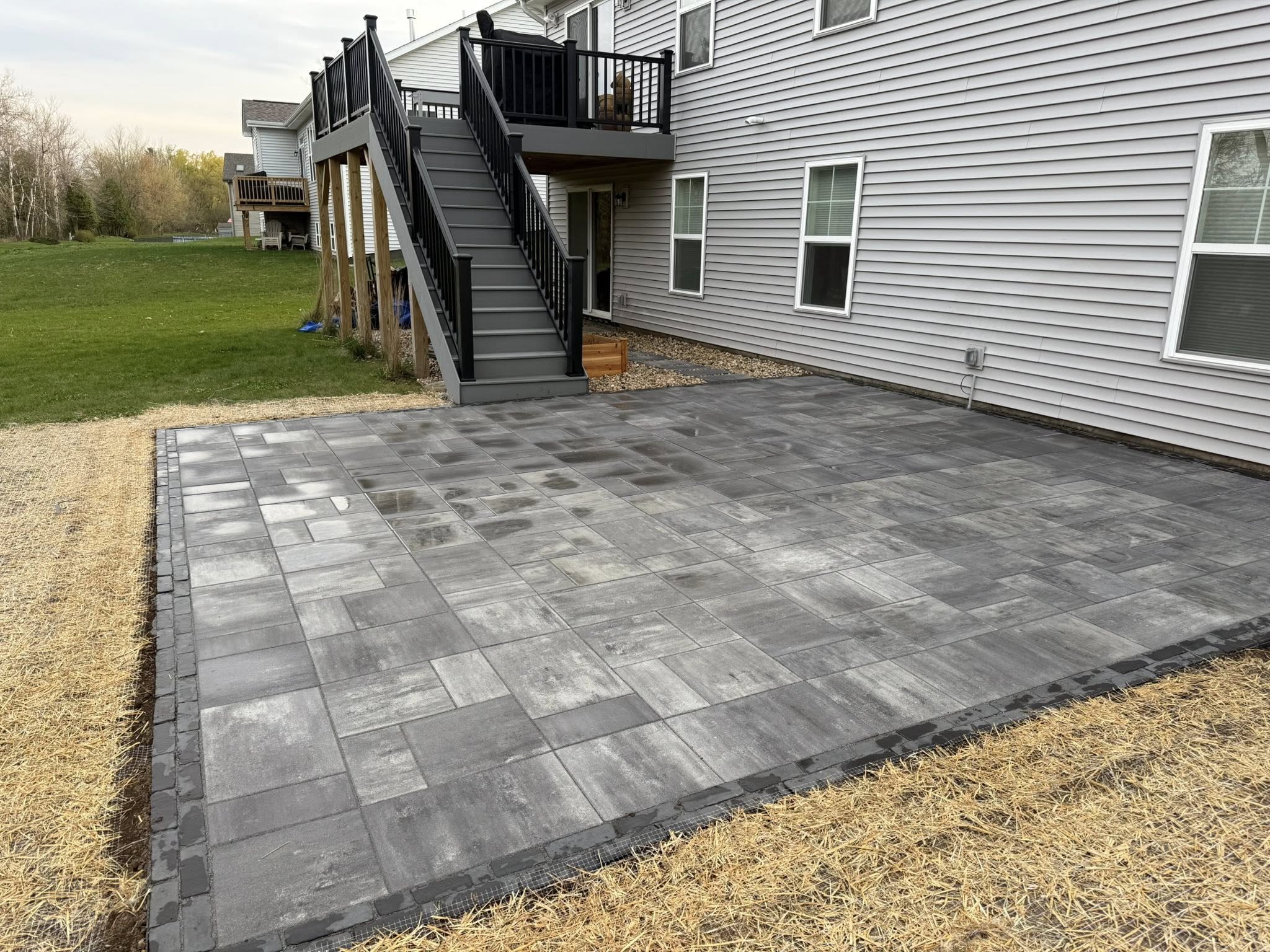 A finished landscape project with a large paver patio and clean border detail